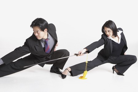Studio shot of Asian businesspeople with swords