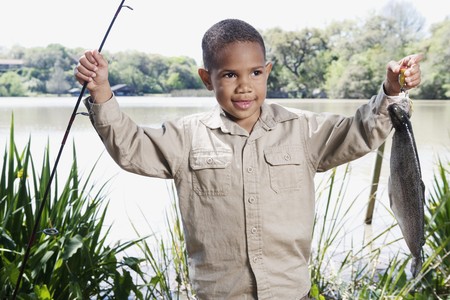 Young African boy with fishing pole and fishの写真素材