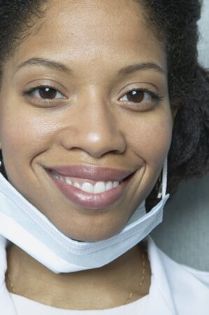 Close up of African woman smiling with surgical maskの写真素材