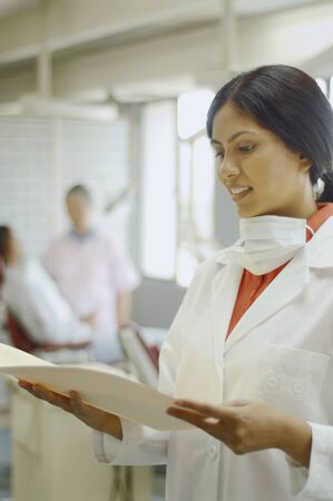 Indian female dentist looking at chartの写真素材