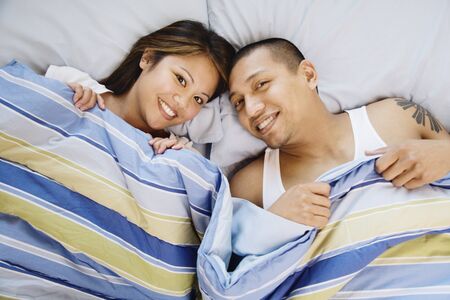 High angle view of Asian couple in bed