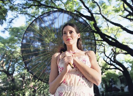 Hispanic woman carrying parasolの写真素材