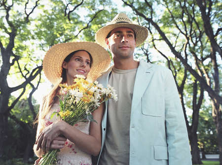 Hispanic couple holding wildflowers at parkの写真素材