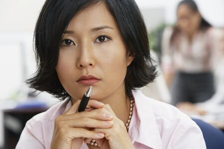Portrait of Asian businesswoman holding penの写真素材