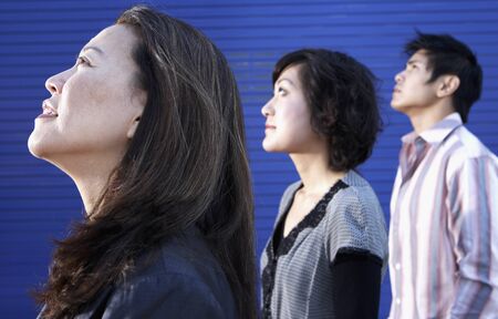Profile of three Asian people looking upの写真素材