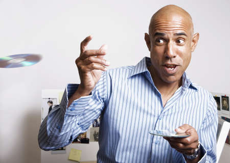 African businessman throwing cds in officeの写真素材
