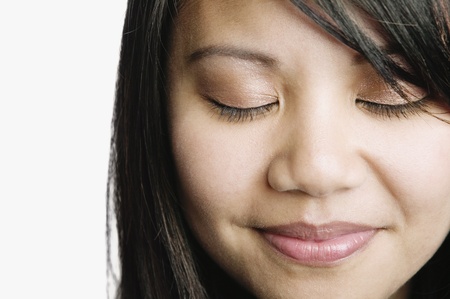 Asian woman smiling with eyes closedの写真素材