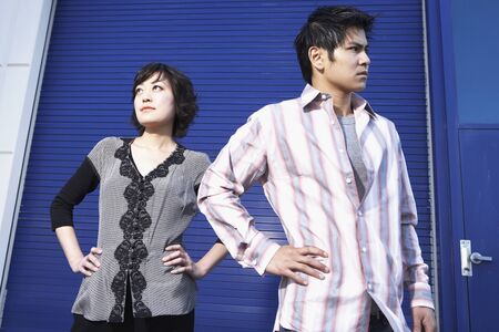 Portrait of young couple with hands on hipsの写真素材