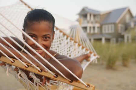 African woman laying in hammock at beachの写真素材