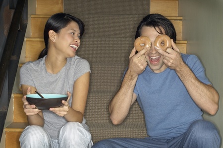 Multi-ethnic couple joking around on stairsの写真素材