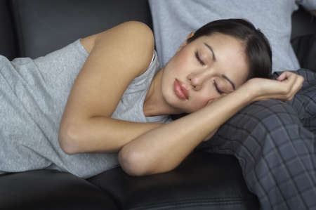 Hispanic woman sleeping on boyfriendÃ¢â‚¬â„¢s leg