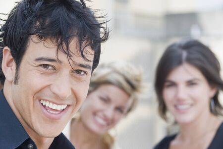 Hispanic man smiling with friends in background