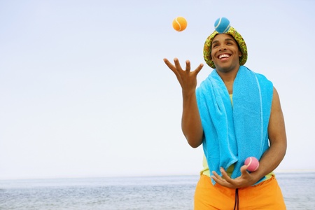 Hispanic man juggling at beachの写真素材