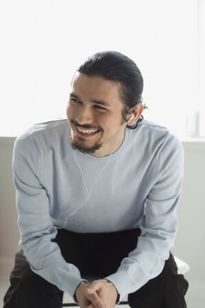 Hispanic man listening to mp3 playerの写真素材