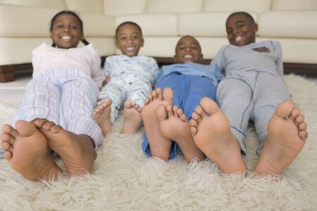 African siblings in pajamas on floorの写真素材