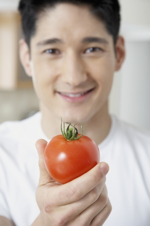Asian man holding tomatoの写真素材