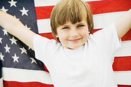 Boy holding up American flagの写真素材