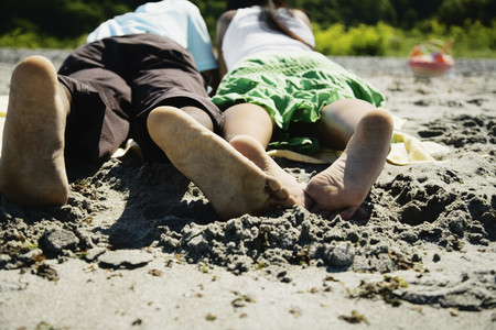 African couple laying on beachの写真素材