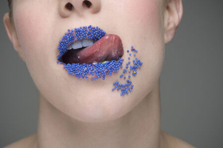 Woman licking sprinkles off lipsの写真素材