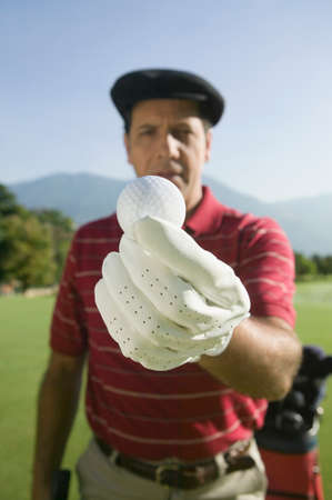 Hispanic man holding golf ballの写真素材