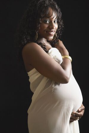Pregnant African American woman with hand on bellyの写真素材