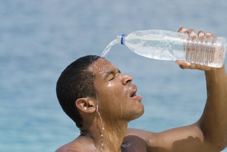 Hispanic man pouring water over headの写真素材
