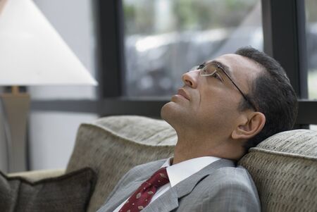 Hispanic businessman on sofaの写真素材