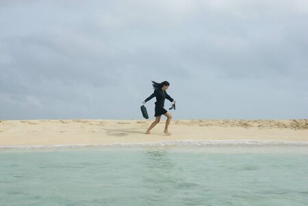 Hispanic businesswoman walking on beach