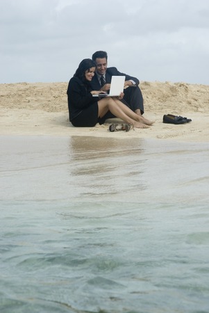 Hispanic businesspeople working at beachの写真素材