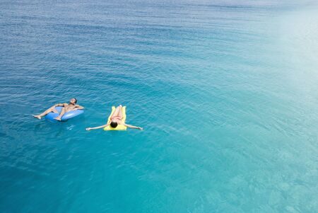 Multi-ethnic couple on floats in water