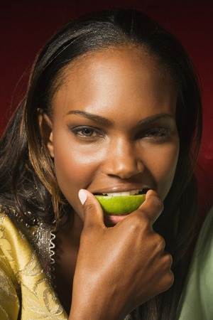 African woman biting lime sliceの写真素材