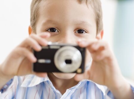 Hispanic boy taking photograph