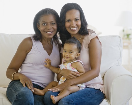 African American grandmother, mother and baby on sofa