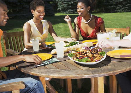 African American friends eating outdoorsの写真素材