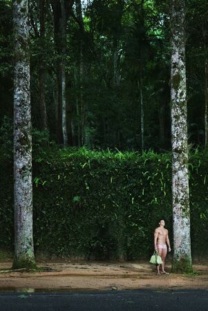 Hispanic man wearing bathing suit in woodsの写真素材