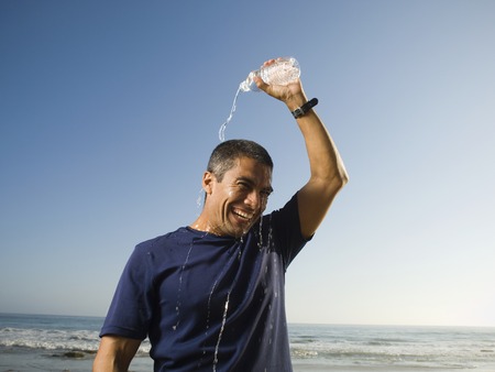 Hispanic man pouring water over headの写真素材