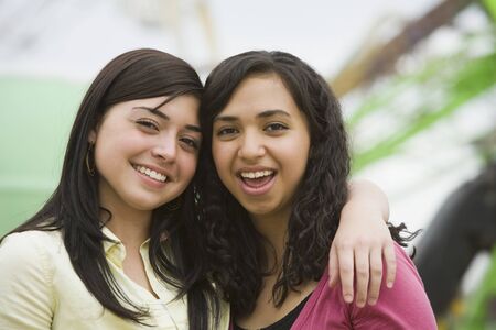 Multi-ethnic teenaged girls hugging