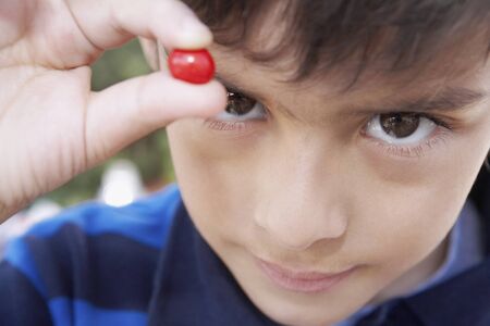 Hispanic boy holding piece of candyの写真素材