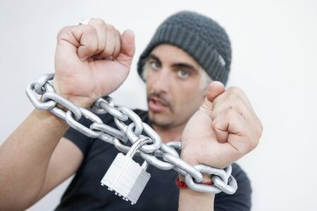 Hispanic man with chains around wristsの写真素材