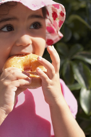 Hispanic baby girl eating doughnutの写真素材