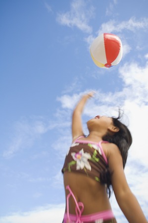 Pacific Islander girl playing with beach ballの写真素材
