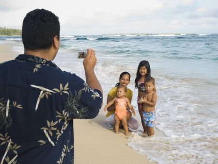 Pacific Islander father taking photograph of familyの写真素材