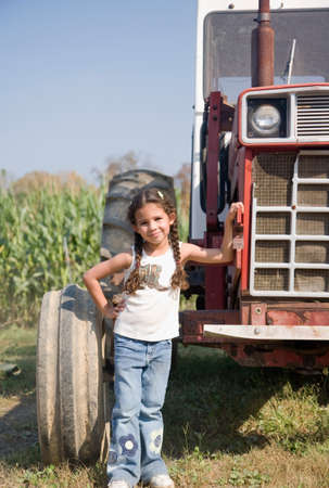 Hispanic girl next to tractorの写真素材