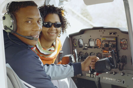 African couple in cockpit of airplaneの写真素材