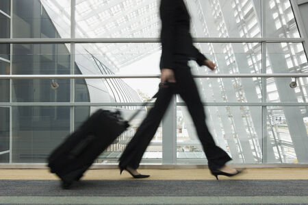 Businesswoman pulling suitcaseの写真素材