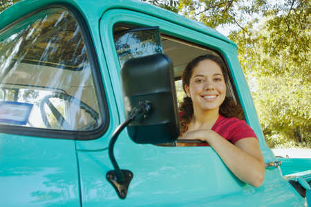 Hispanic woman sitting in truckの写真素材