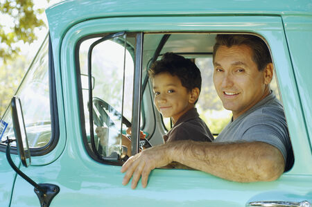 Hispanic father and son sitting in truckの写真素材