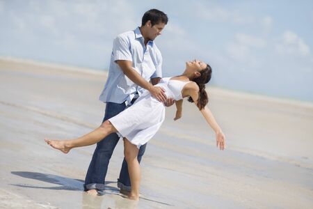 Hispanic couple dancing at beachの写真素材