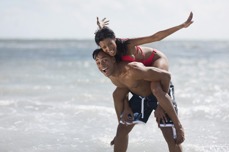 African man giving girlfriend piggy back rideの写真素材