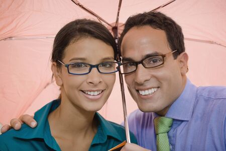 Hispanic couple standing under umbrellaの写真素材